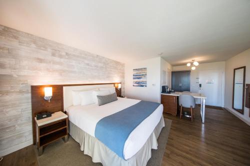 a hotel room with a large bed and a kitchen at SeaCrest Oceanfront Hotel in Pismo Beach