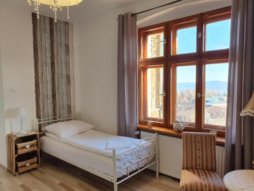 een slaapkamer met een bed en een groot raam bij Lux Apartament ,,Górskie Widoki '' Karpacz Mountain Views in Karpacz