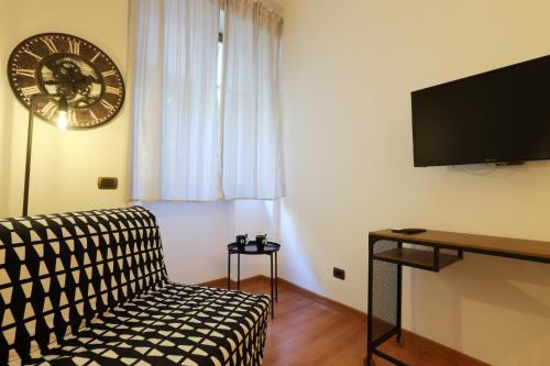a living room with a couch and a clock on the wall at Napoli Vesuvio Apartments by Dimorra in Naples