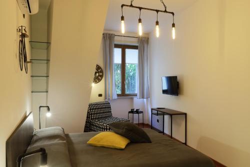 a bedroom with a bed and a chair and a window at Napoli Vesuvio Apartments by Dimorra in Naples