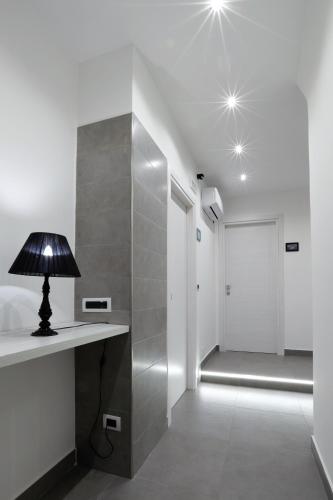 a lamp on a table in a room with a walk in shower at Napoli Vesuvio Apartments by Dimorra in Naples