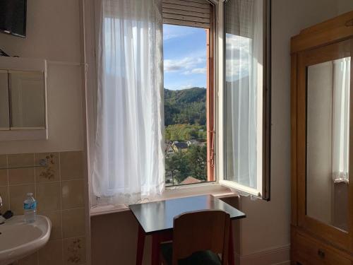a bathroom with a sink and a window with a view at Chambre Arnica lit 140 wifi sdb partagée in Saint-Amarin