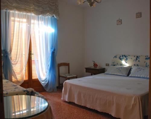 een slaapkamer met een bed en een raam met gordijnen bij Bed and Breakfast Il Girasole in Lamporecchio