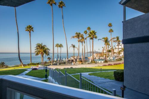a view of the beach and palm trees from a balcony at SeaCrest Oceanfront Hotel in Pismo Beach