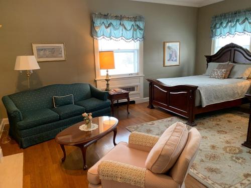 sala de estar con cama y sofá en Farrell House Lodge at Sunnybrook Trout Club, en Sandusky