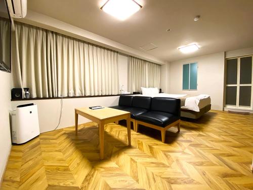 大阪市にある天王寺ラグーンホテルのベッド、ソファ、テーブルが備わる客室です。