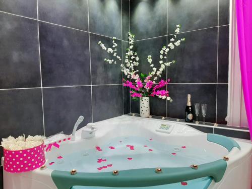 a bathroom with a tub with a vase of flowers at Red House in Naples