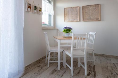 a dining room table with two chairs and a vase with flowers at Il bianconido in Castel Gandolfo