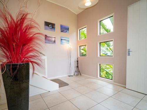 a hallway with a vase with a plant in it at At Cathedral Cove - Hahei Holiday Home in Hahei