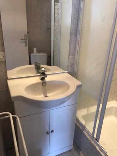 a white bathroom with a sink and a shower at Studio CENTRE CROISETTE in Cannes