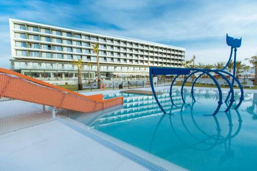30º Hotels - Hotel Dos Playas Mazarrón في بويرتو دي مازارون: مسبح في خلفية مبنى كبير