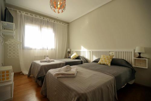 A bed or beds in a room at Apartamento , wifi y garaje cerca del centro