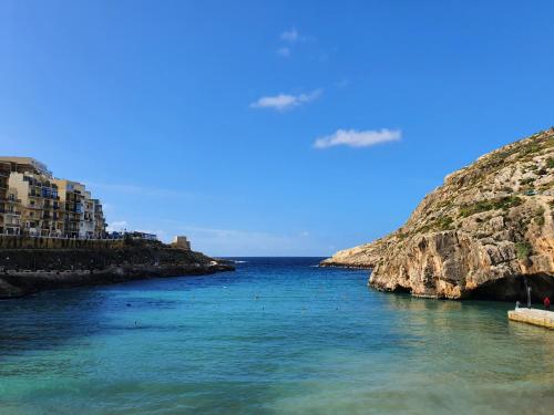 una vista de un cuerpo de agua junto a un acantilado en Mobydick Apartments by RBG, en Xlendi