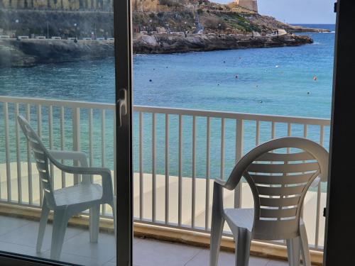 balcón con 2 sillas y vistas al océano en Mobydick Apartments by RBG, en Xlendi