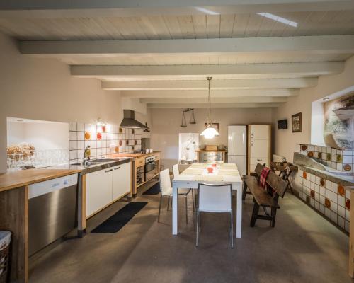 a large kitchen with a white table and chairs at Pazo de Lemaio in Laracha