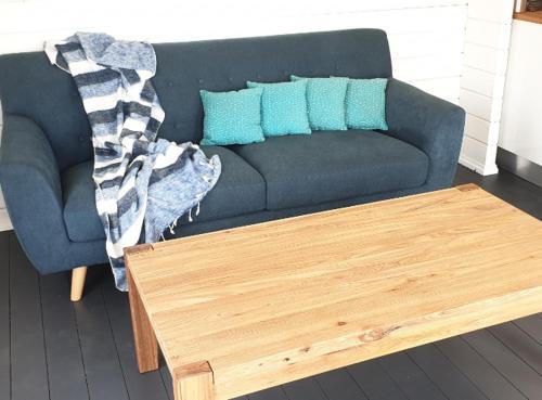 a living room with a couch and a coffee table at SeaView Retreat -Amazing Ocean Views and Outdoor bath in Waiuku