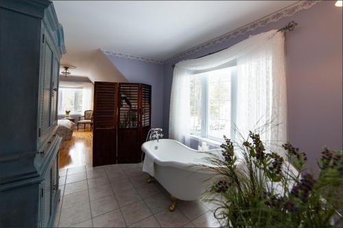 bagno con vasca e finestra di Au coeur de Saint-Sauveur a Saint-Sauveur-des-Monts