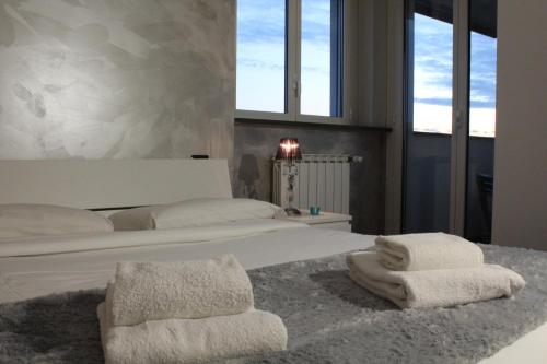 a bedroom with a white bed with towels on it at City View Living in Milan
