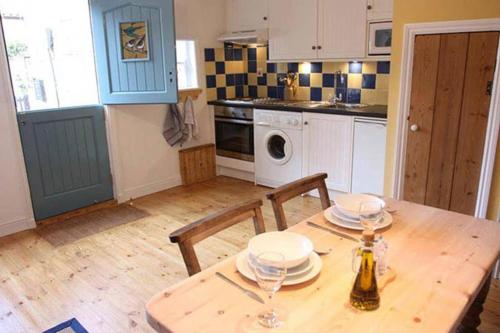 a kitchen with a wooden table with two chairs and a table sidx sidx at Dunsley Cottage in Staithes