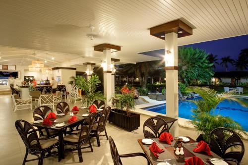 a restaurant with tables and chairs and a pool at Fiji Gateway Hotel in Nadi