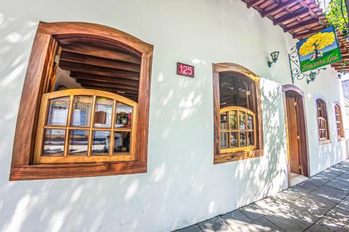 two windows on the side of a building at Pousada Ipê in São Sebastião