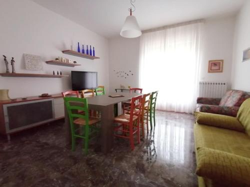a living room with a table with chairs and a couch at Appartamento CUPRA in Cupra Marittima