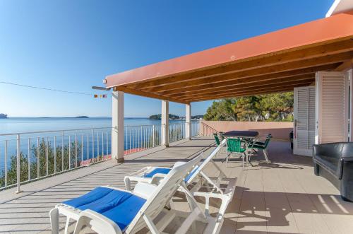 a deck with chairs and tables and a grill at Apartments Ivan in Prizba