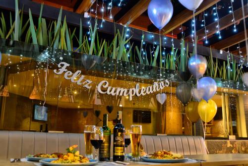 a restaurant with two plates of food and balloons at Turrim Dei Hotel Boutique in Barbosa