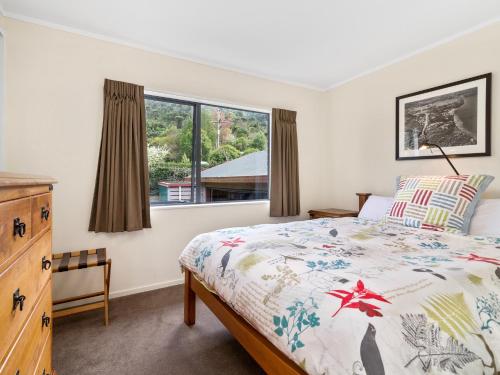 1 dormitorio con cama y ventana en Lakeside Escape - Lake Tarawera Holiday Home, en Lake Tarawera