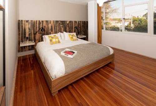 1 dormitorio con 1 cama grande, suelo de madera y ventana en Don Jacinto Stay&Sip en Ciudad de México