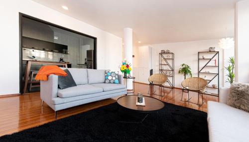 a living room with a couch and a table at Don Jacinto Stay&Sip in Mexico City