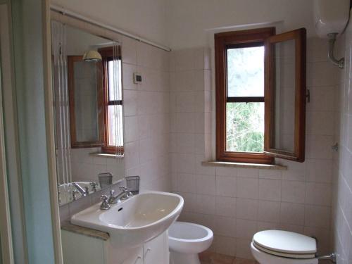 a white bathroom with a sink and a toilet at Apartment- Rosa 4+2 in Sassetta