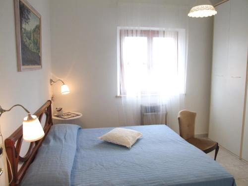 a bedroom with a blue bed and a window at Apartment- Rosa 4+2 in Sassetta