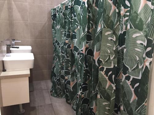 a bathroom with a toilet and a shower curtain at JJ's Backpackers in Perth