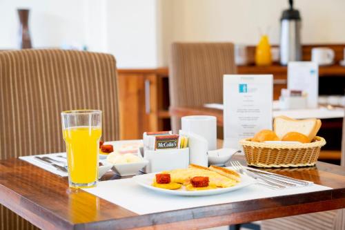 a table with a plate of food and a glass of orange juice at El Dorado Express Hotel in Iquitos