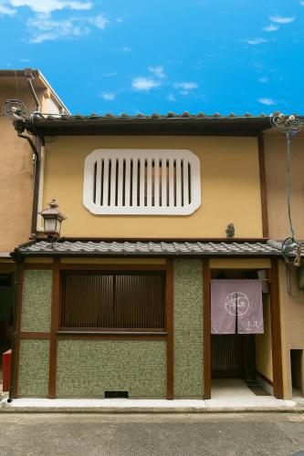a facade of a building with a window at Mokuren Traditional Boutique Townhouse in Kyoto
