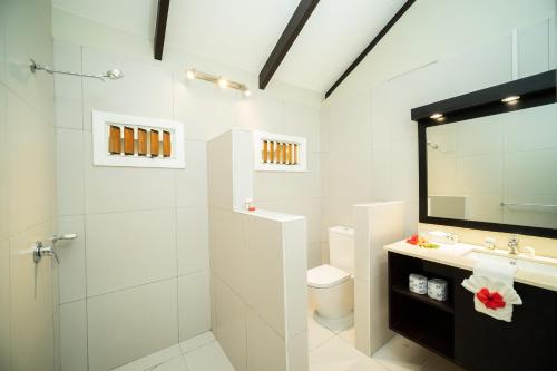 W łazience znajduje się umywalka, toaleta i lustro. w obiekcie Plantation Island Resort w mieście Malolo Lailai