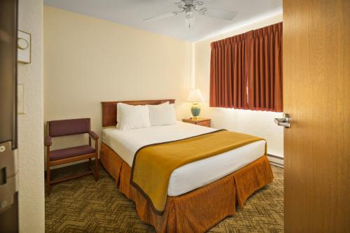 a hotel room with a bed and a chair at Black Hills Luxury Suites in Hill City