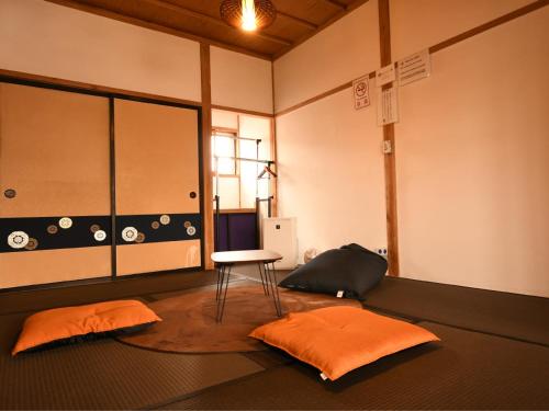 een kamer met een stoel en 2 kussens op de vloer bij Tsubaki - the best guesthouse in Inawashiro - in Inawashiro