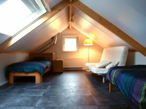 a attic room with two beds and a window at Boerderij het Reestdal in Linde