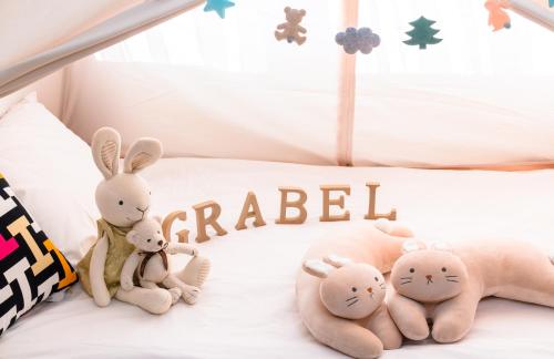 a group of stuffed animals sitting on a bed at Grabel Hotel Jeju in Jeju