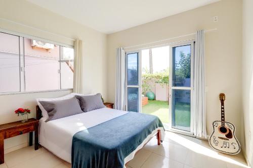 a bedroom with a bed and a guitar in it at Pousada Origin in Guarda do Embaú