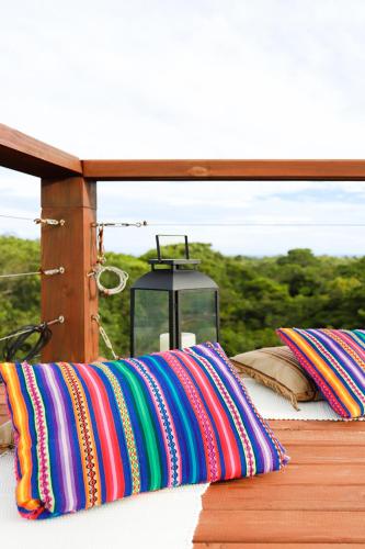 a group of colorful pillows sitting on a deck at Pousada Origin in Guarda do Embaú