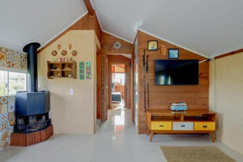 a living room with a tv and a table at Pousada Origin in Guarda do Embaú