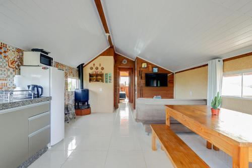 a kitchen and living room with a wooden table at Pousada Origin in Guarda do Embaú