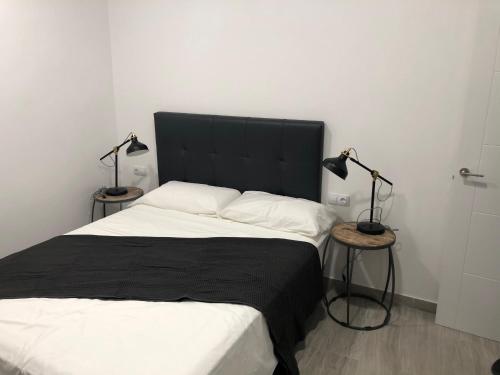 a bedroom with a bed and a lamp at Brazan Holidays in Corralejo