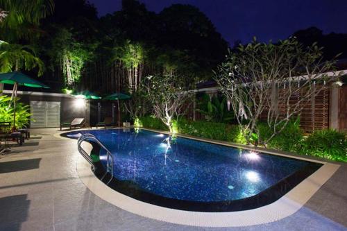 a swimming pool in a backyard at night at Kata Tranquil Villa - SHA Plus in Karon Beach