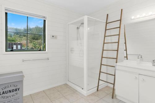 Baño con una escalera junto a una ducha en Kiwi Kuta with direct beach access -Matarangi Home en Matarangi