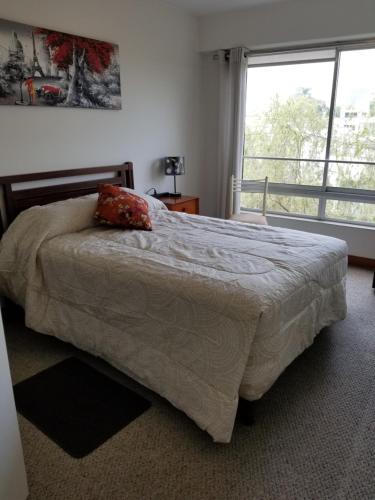 een slaapkamer met een bed en een groot raam bij Dormitorio Privado dentro de Departamento in Lima