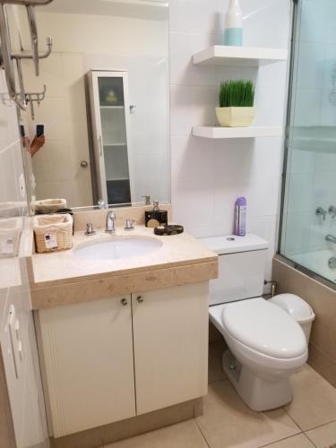 a bathroom with a sink and a toilet and a mirror at Dormitorio Privado dentro de Departamento in Lima